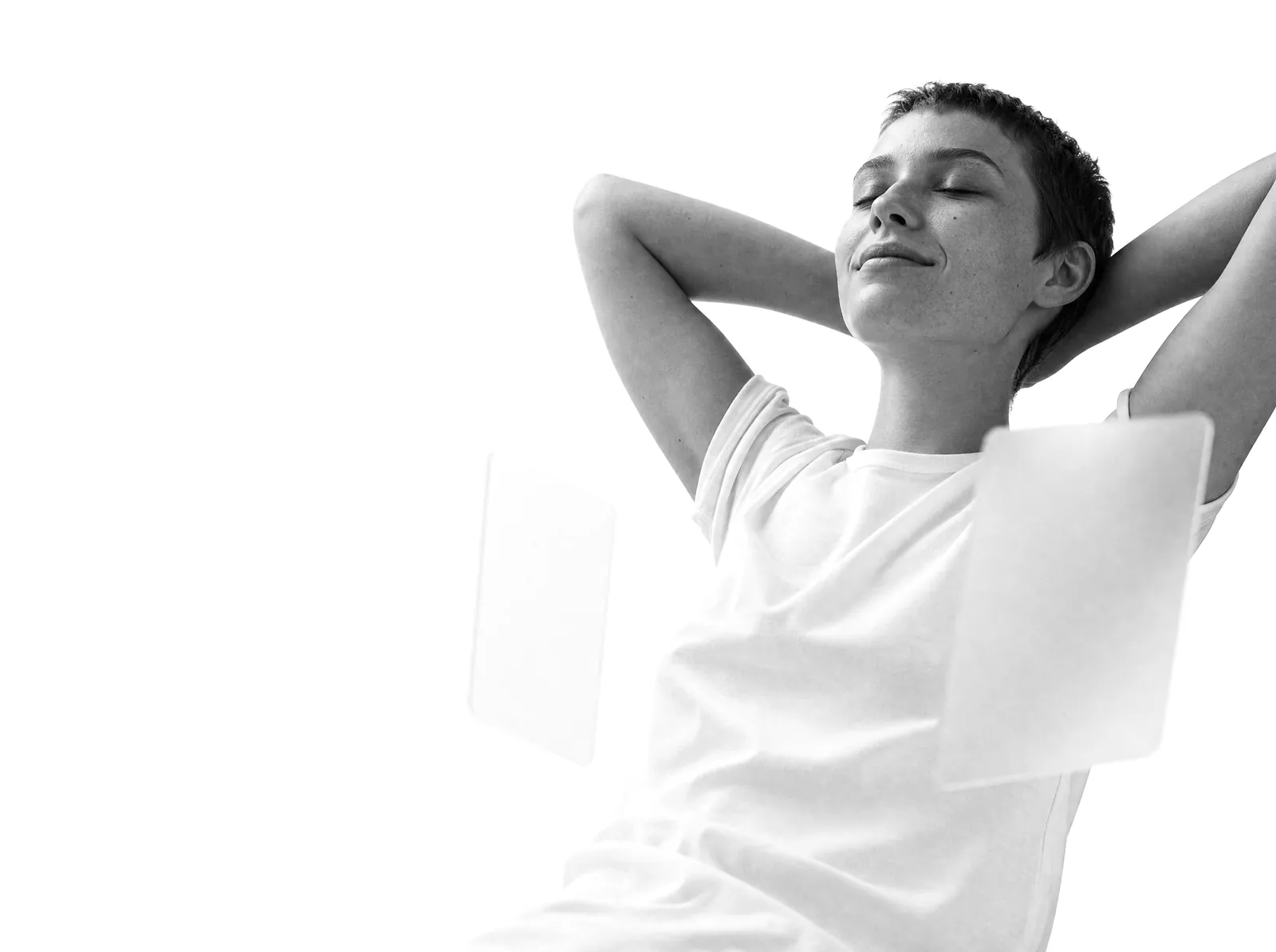 A relaxed person leaning back with hands behind the head, eyes closed.